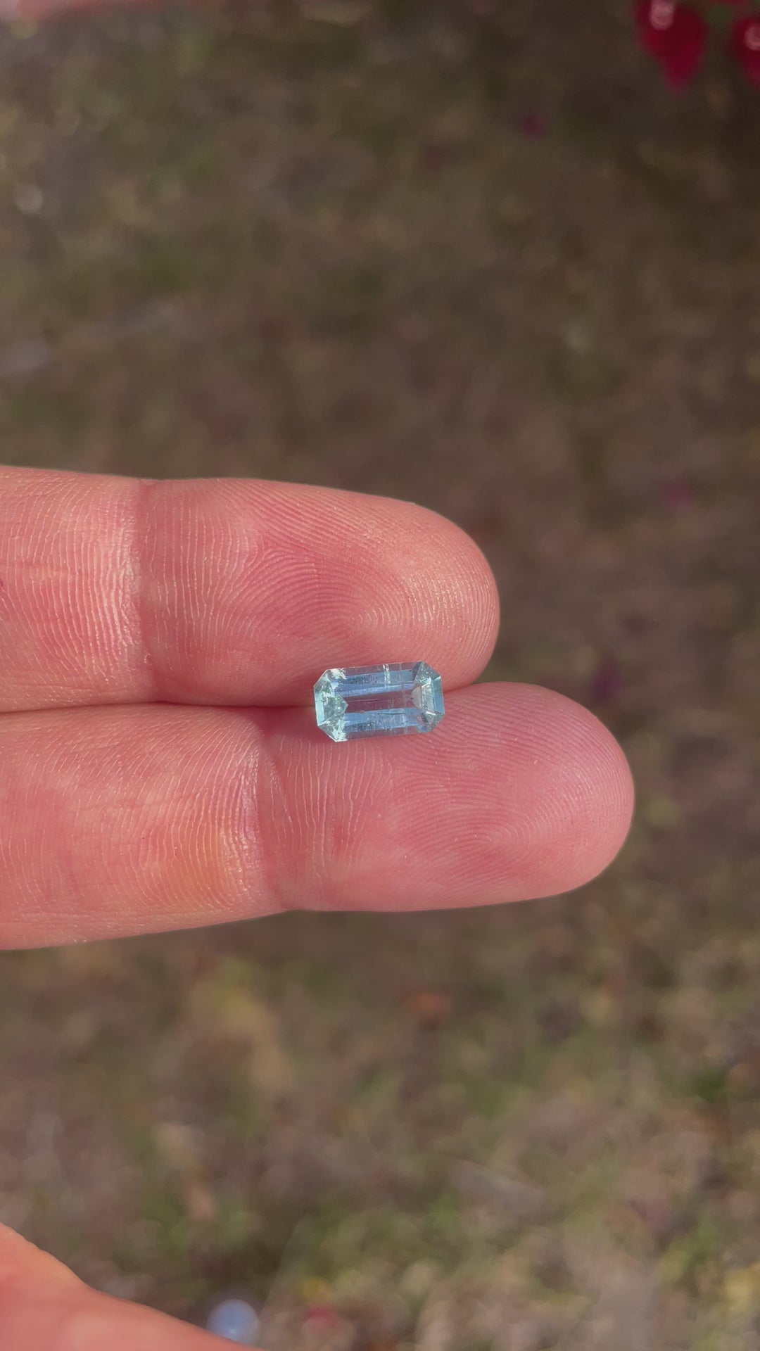 Detailed video showcasing the clarity and vibrant colors of a natural 1.72-carat emerald-cut aquamarine gemstone, untreated and ethically sourced.