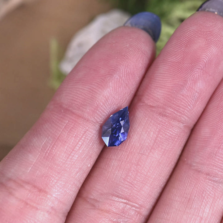 Rotating loose blue purple sapphire custom pear cut from Sri Lanka revealing vivid blue tones and sparkle as the gemstone turns in the light.