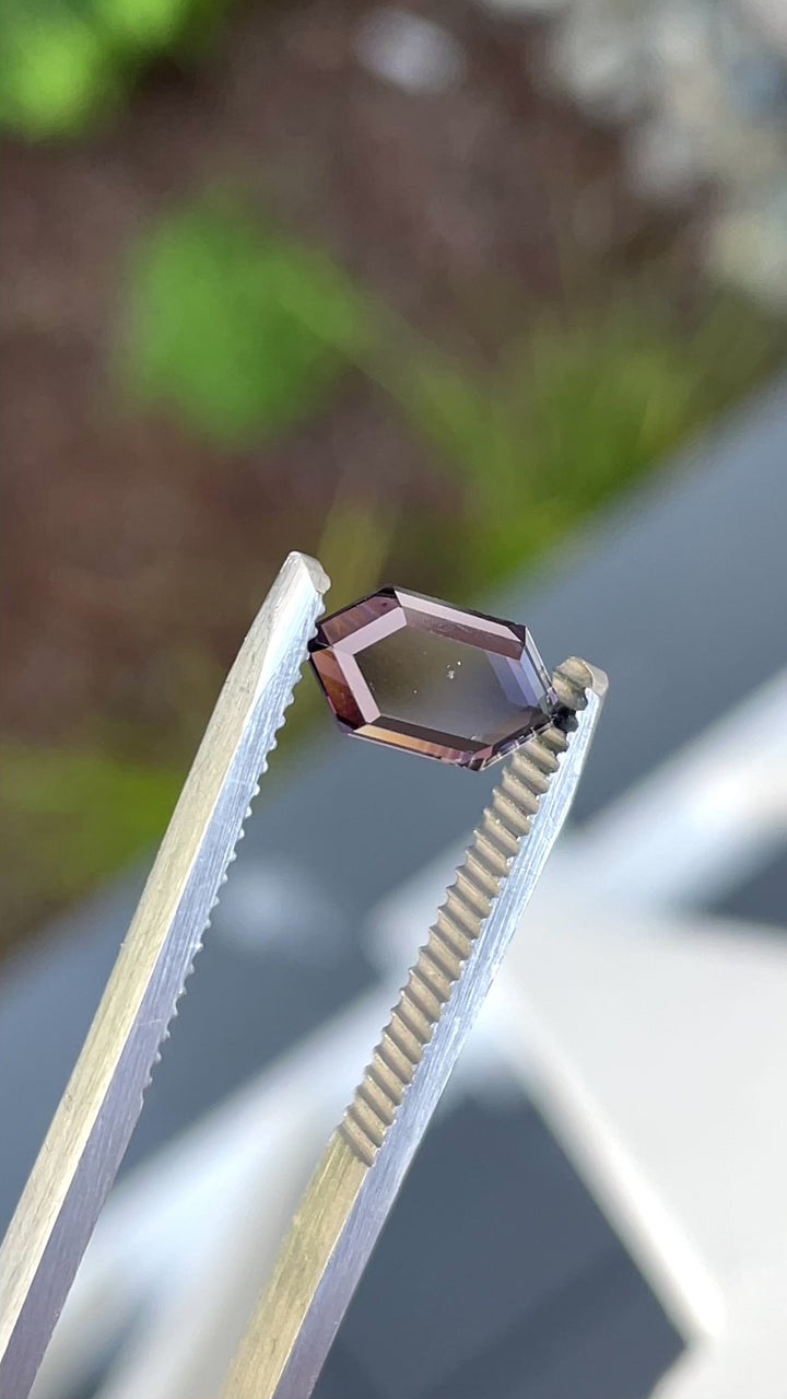 Video of a hexagon-shaped 1.77 Purple and Pink spinel sparkling in daylight, showcasing expert faceting.