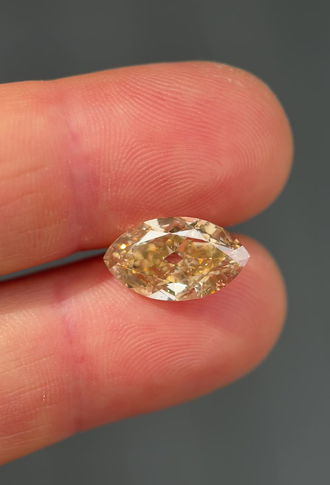 UV fluorescence video of a 4.01 carat rosy champagne natural fancy yellow brown diamond from South Africa glowing vivid blue under ultraviolet light, highlighting its untreated nature and strong fluorescence.