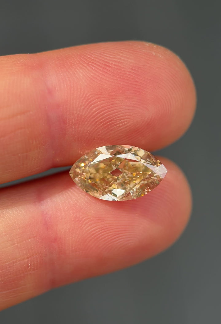UV fluorescence video of a 4.01 carat rosy champagne natural fancy yellow brown diamond from South Africa glowing vivid blue under ultraviolet light, highlighting its untreated nature and strong fluorescence.