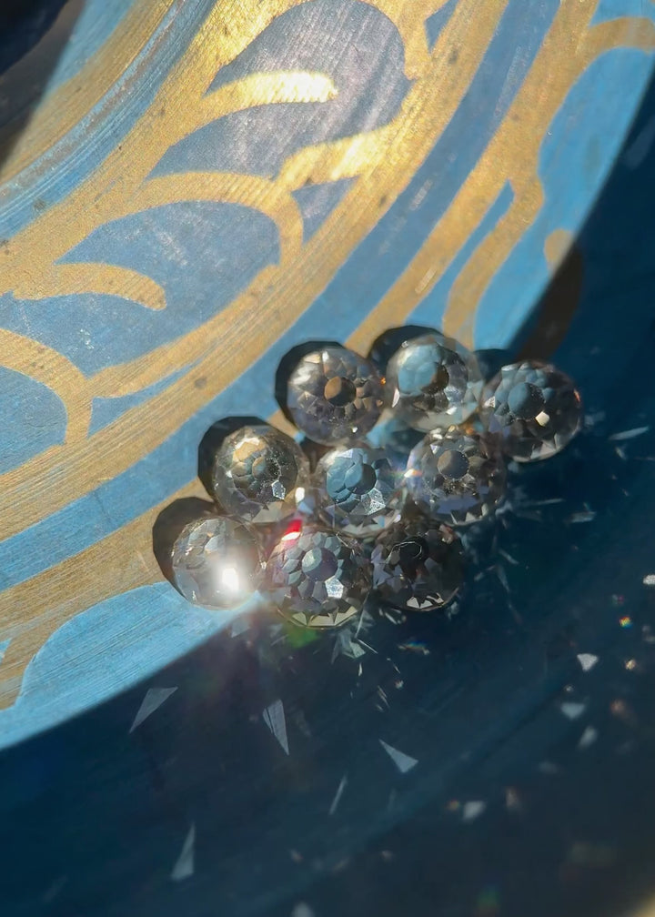 Video rotating a nine-piece Mughal cut diamond parcel under shifting light to reveal antique faceting, open culets, light blue fluorescence, and fancy light brown color in untreated South African diamonds