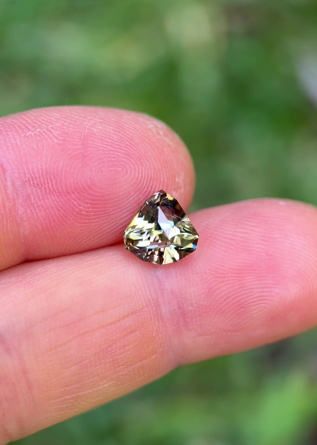 Rotating hand video of 2.87ct Tanzanite with pink, yellow, and teal flashes in shield mixed cut from Tanzania