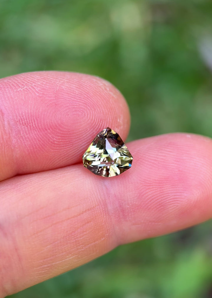 Rotating hand video of 2.87ct Tanzanite with pink, yellow, and teal flashes in shield mixed cut from Tanzania