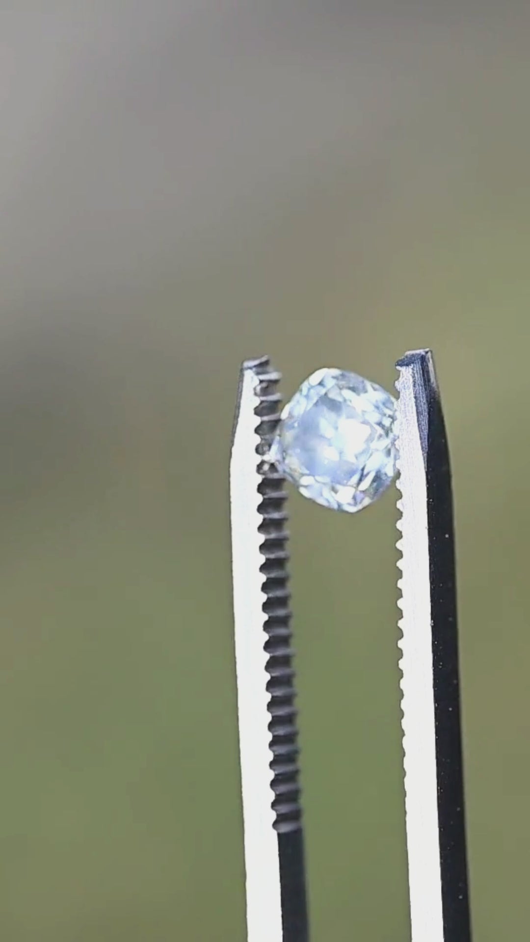 A 0.92 carat antique-style cushion cut diamond rotating in direct sunlight, displaying bright flashes, bold reflections, and timeless Old Mine inspired character.