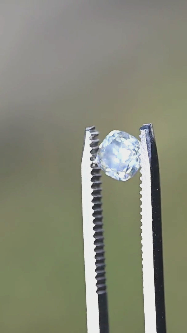 A 0.92 carat antique-style cushion cut diamond rotating in direct sunlight, displaying bright flashes, bold reflections, and timeless Old Mine inspired character.