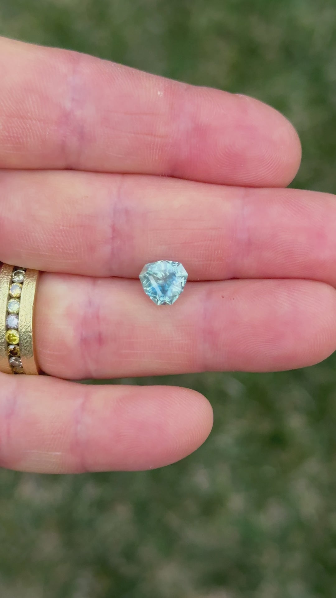 Rotating video of custom-cut Montana sapphire with heated treatment, featuring denim and periwinkle tones under natural light.