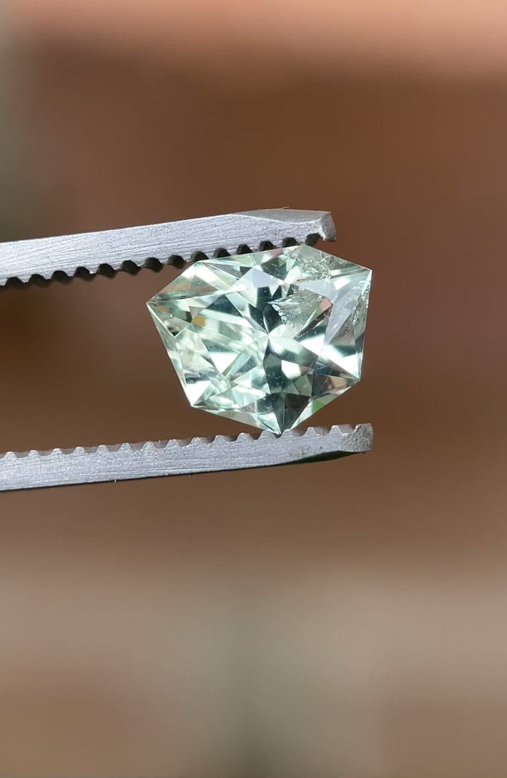 Rotating video of a 1.80ct unheated trillion sapphire showing yellow, green, and blue flashes under natural light.