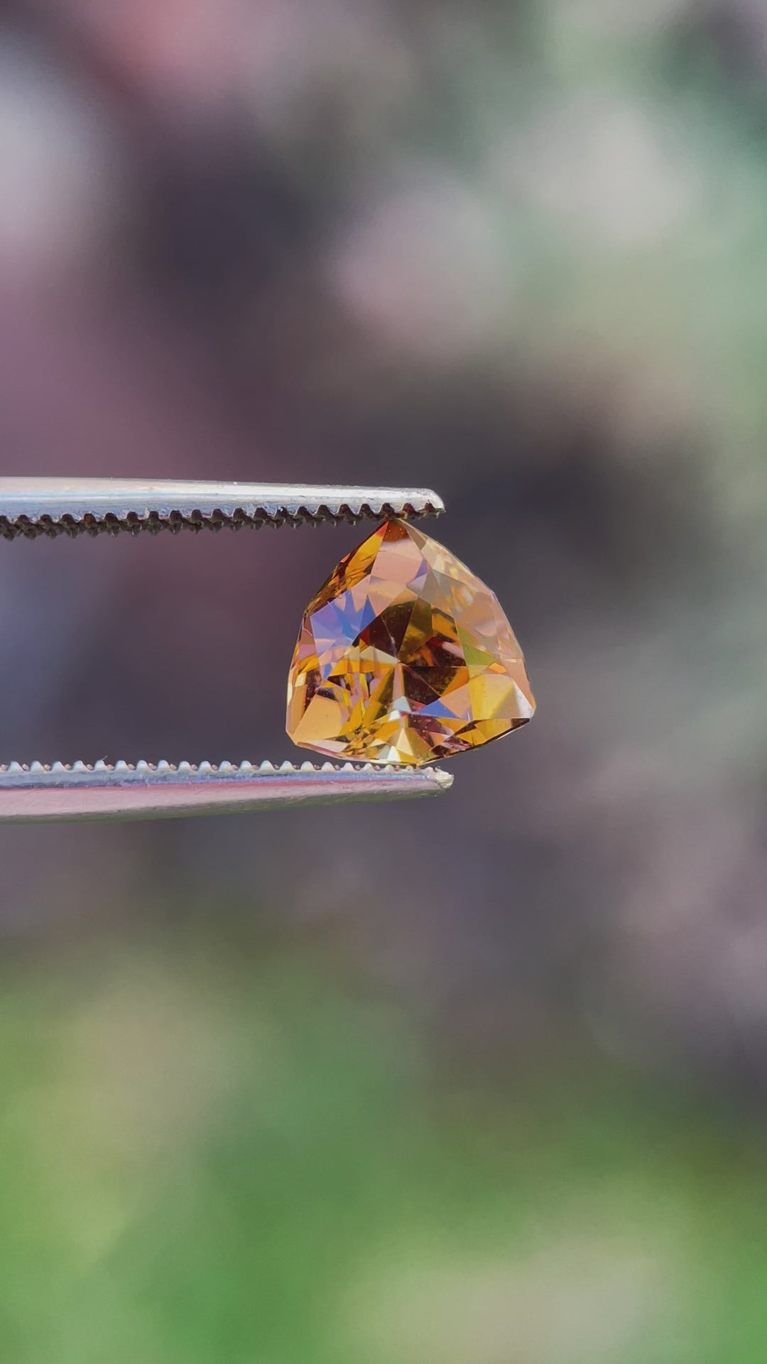 Close-Up Video of a Custom Trilliant Cut Tanzanite Gemstone in Vivid Peach Orange Color, Weighing 2.01 Carats, with Dimensions 8.06 x 8.14 x 5.32 mm, Originating from Merelani Hills, Arusha Region, Tanzania - No Treatment