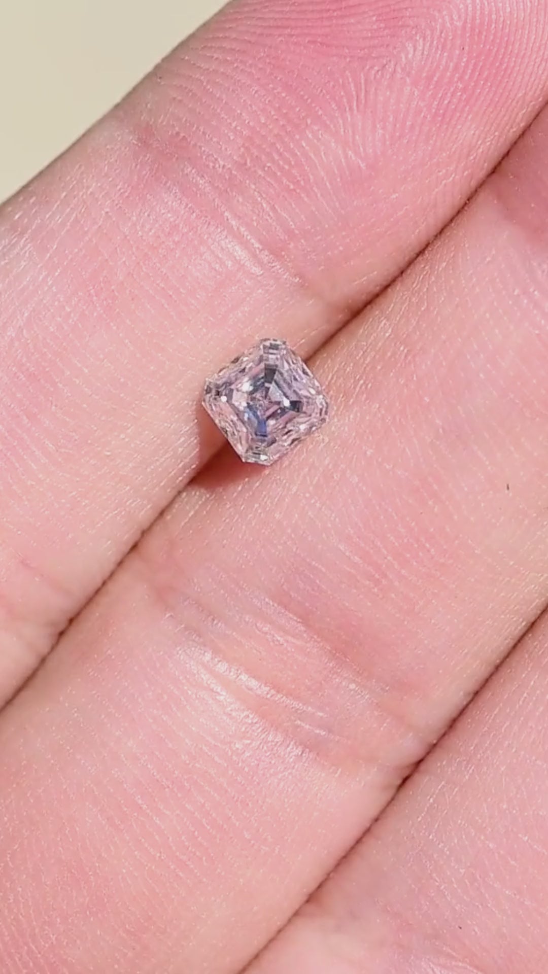 0.90 carat M VVS1 Asscher cut Canadian diamond shown in motion near a hand, demonstrating its scale and shifting geometric reflections.