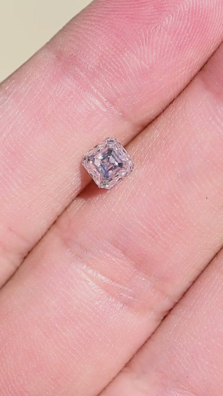 0.90 carat M VVS1 Asscher cut Canadian diamond shown in motion near a hand, demonstrating its scale and shifting geometric reflections.