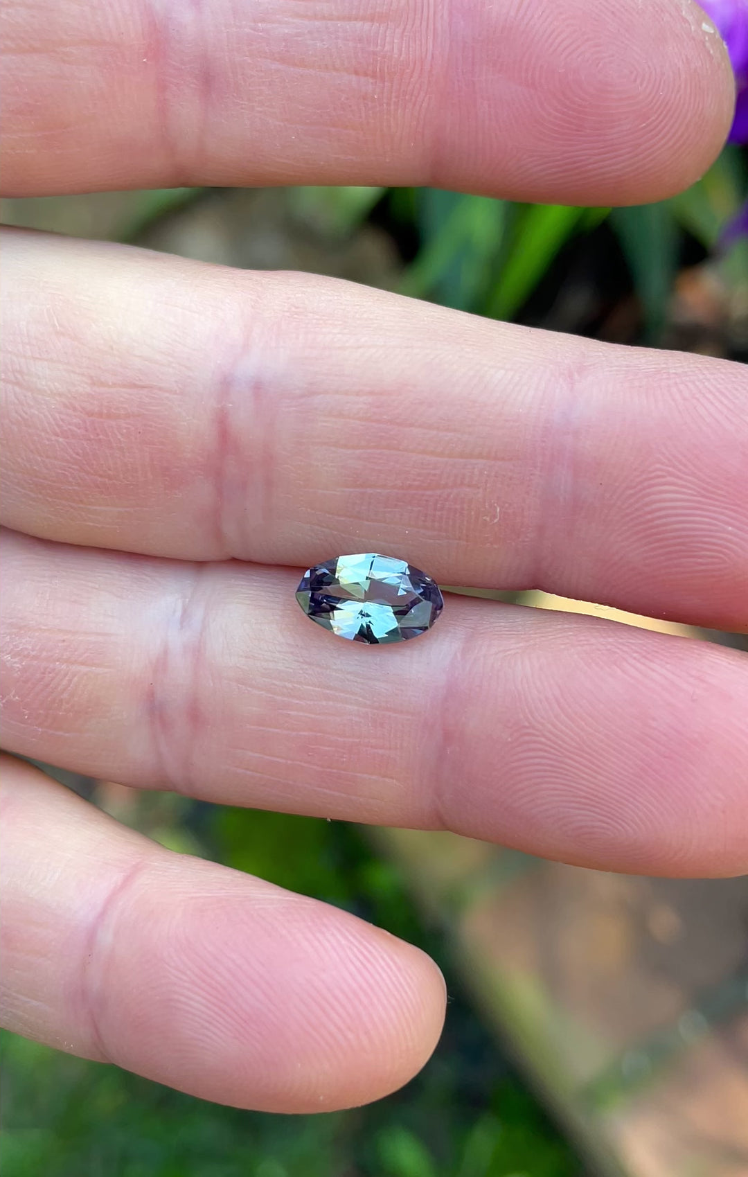 Close-up video of custom oval Tanzanite in shifting mermaid tones, filmed outdoors to capture true color play.