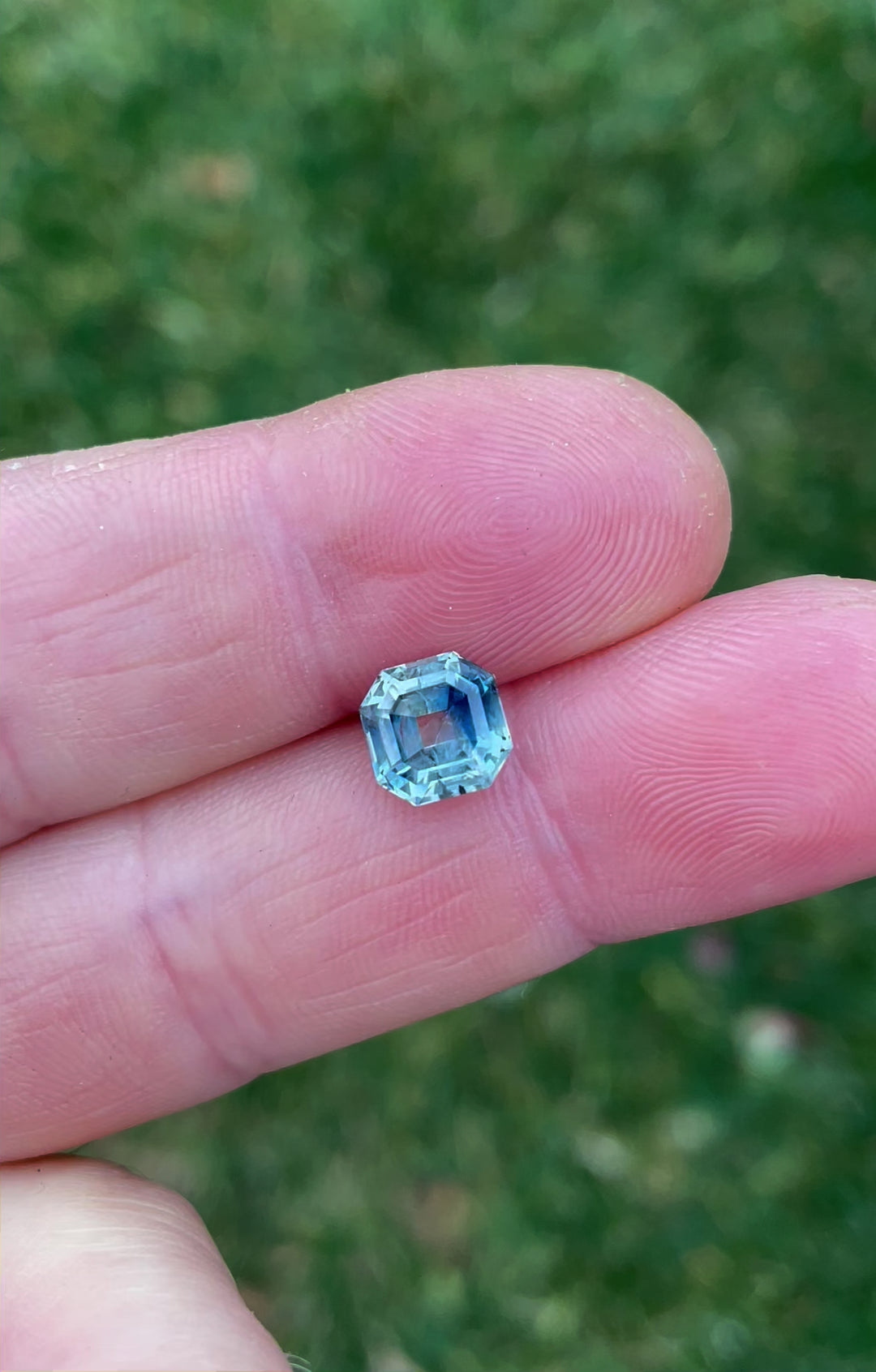 360-degree rotating video of a 2.45-carat parti blue-green sapphire in an antique emerald cut, emphasizing its clarity, vibrant hues, and antique-style proportions.