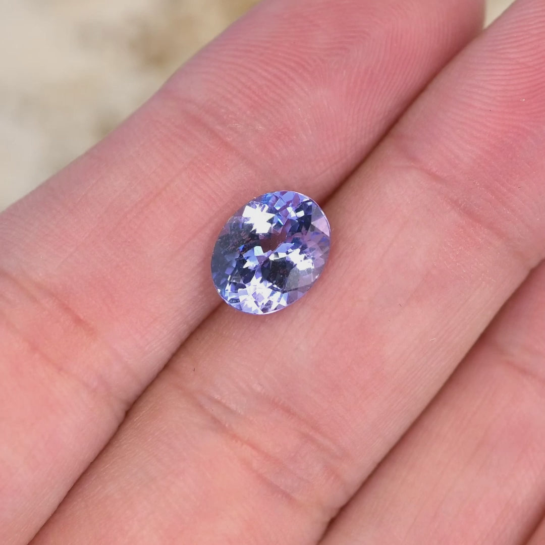Close up video of 2.50ct oval Tanzanite displaying brilliant faceting sparkle and powder blue lavender violet tones ideal for fine jewelry