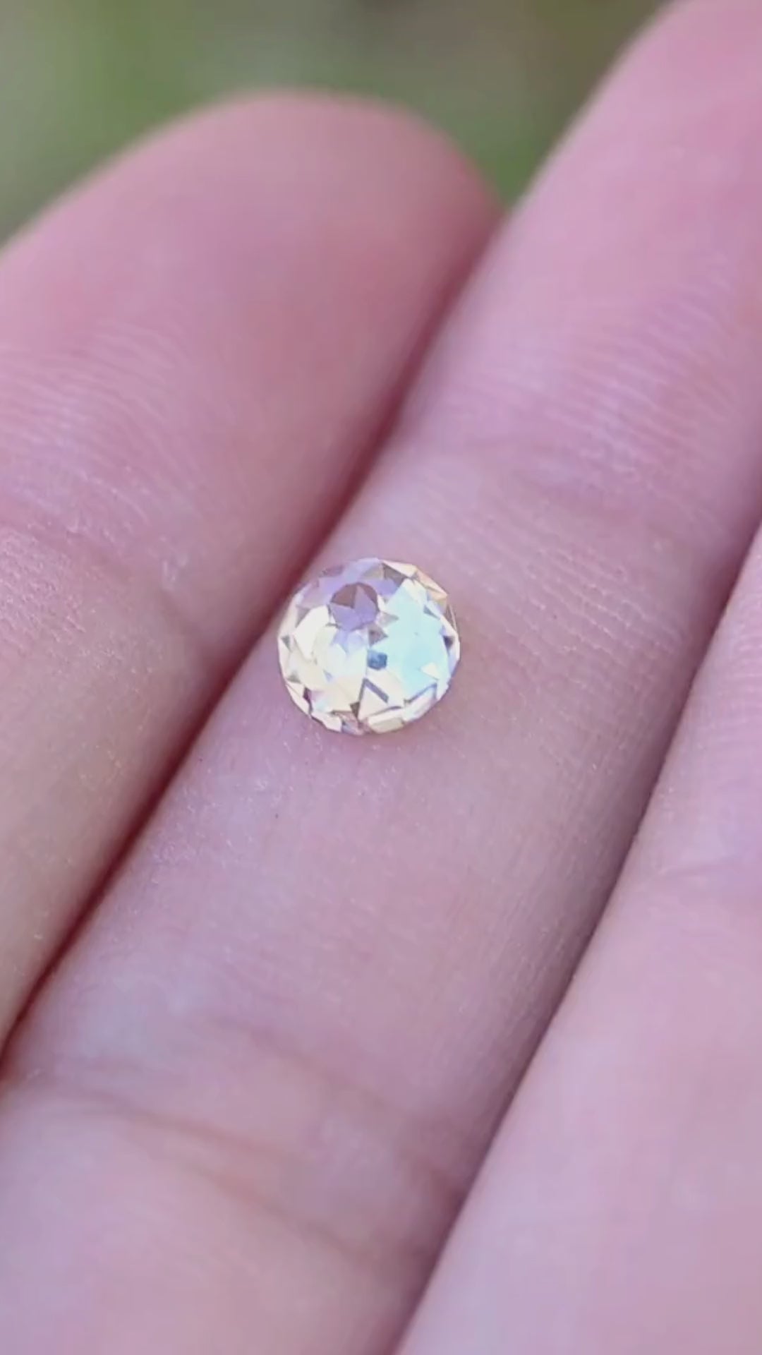 0.99 carat round Mughal cut diamond shown in motion on a hand, revealing its scale and shifting pale champagne, white and cool reflections.