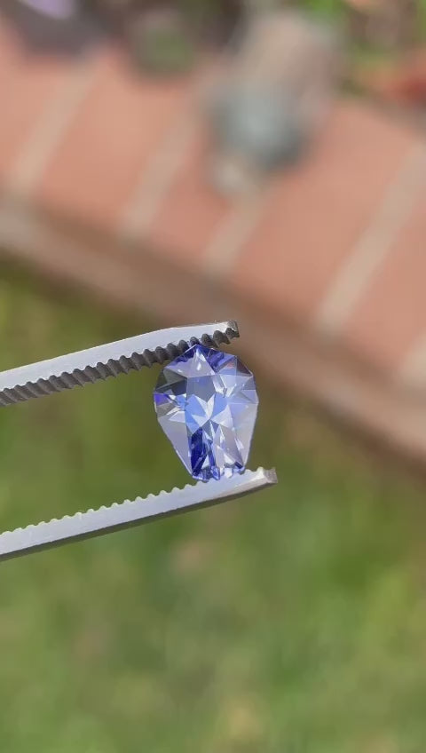 Brilliant 2.26-carat Tanzanite gemstone with ultra violet blue color, custom geometric teardrop cut, showcased elegantly. Originating from the Merelani Hills in the Arusha Region of Tanzania, this exquisite gem measures 10.00 x 7.16 x 5.45 mm and is valued at $2147, reflecting its unique provenance and stunning visual appeal.