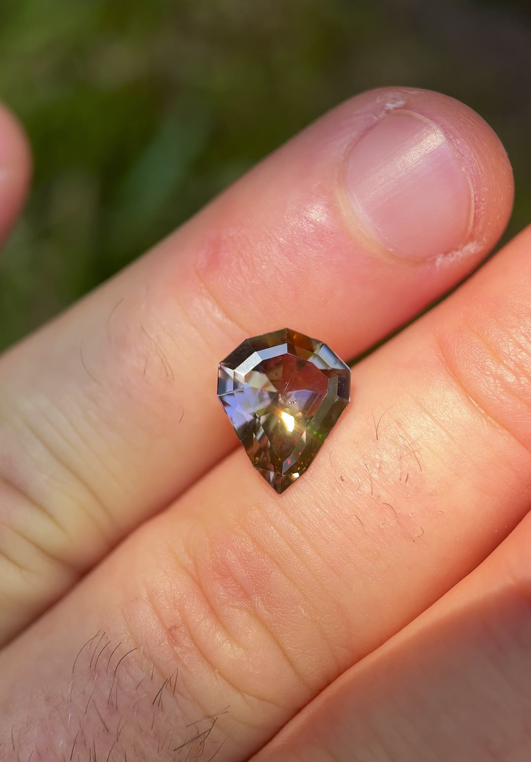 Handheld video of untreated 3.74ct Tanzanite in custom shield cut showing color shift and brilliance under sunlight