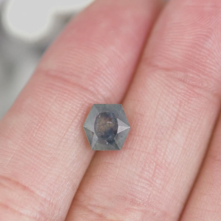 Macro video of 2.00 carat hexagonal brilliant tablet cut Montana sapphire turning to reveal teal and blue gradient tones, untreated gemstone from El Dorado Bar Deposit Montana USA