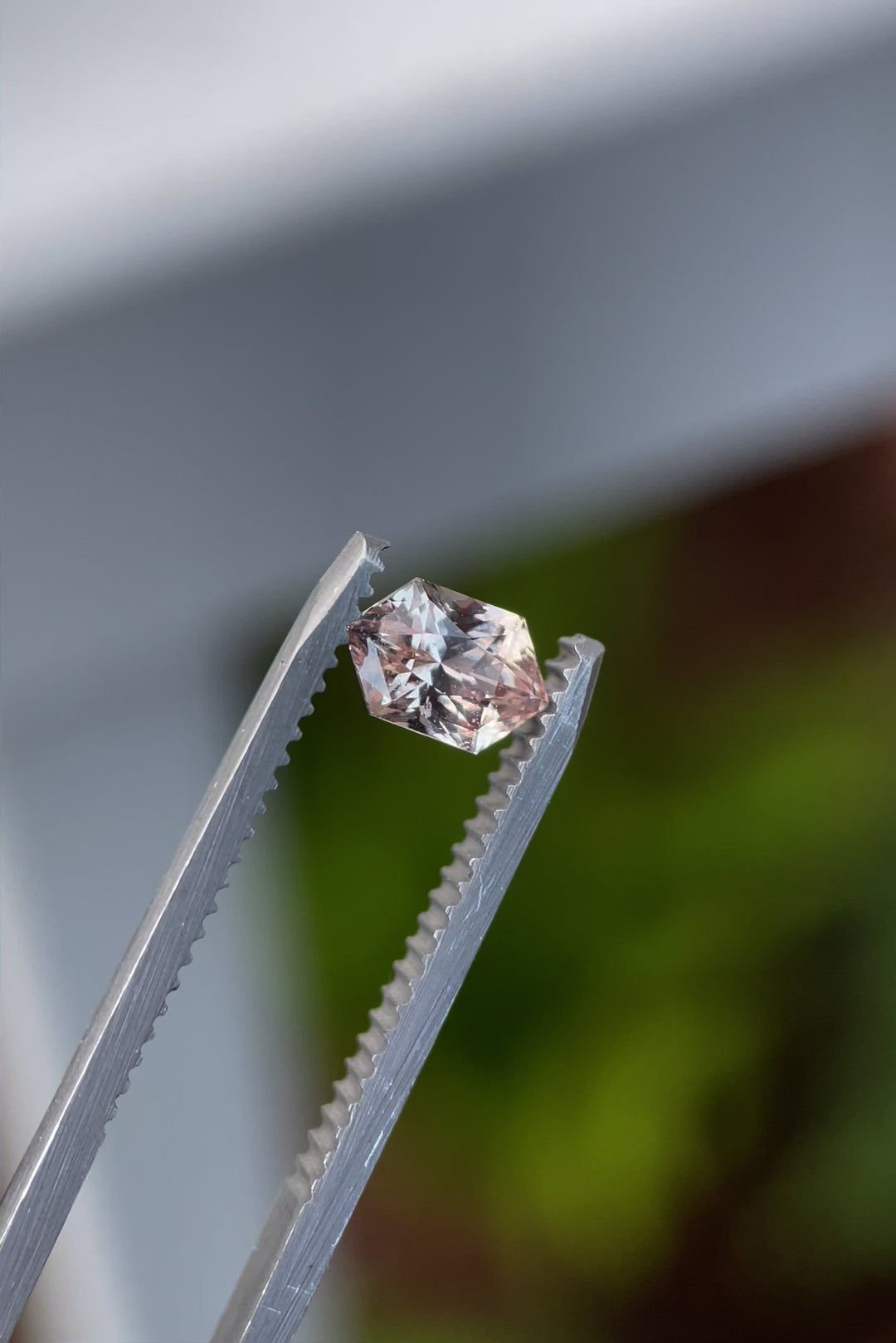 Video of a hexagonal mix brilliant cut peach champagne sapphire being rotated to display its facets and light dispersion.