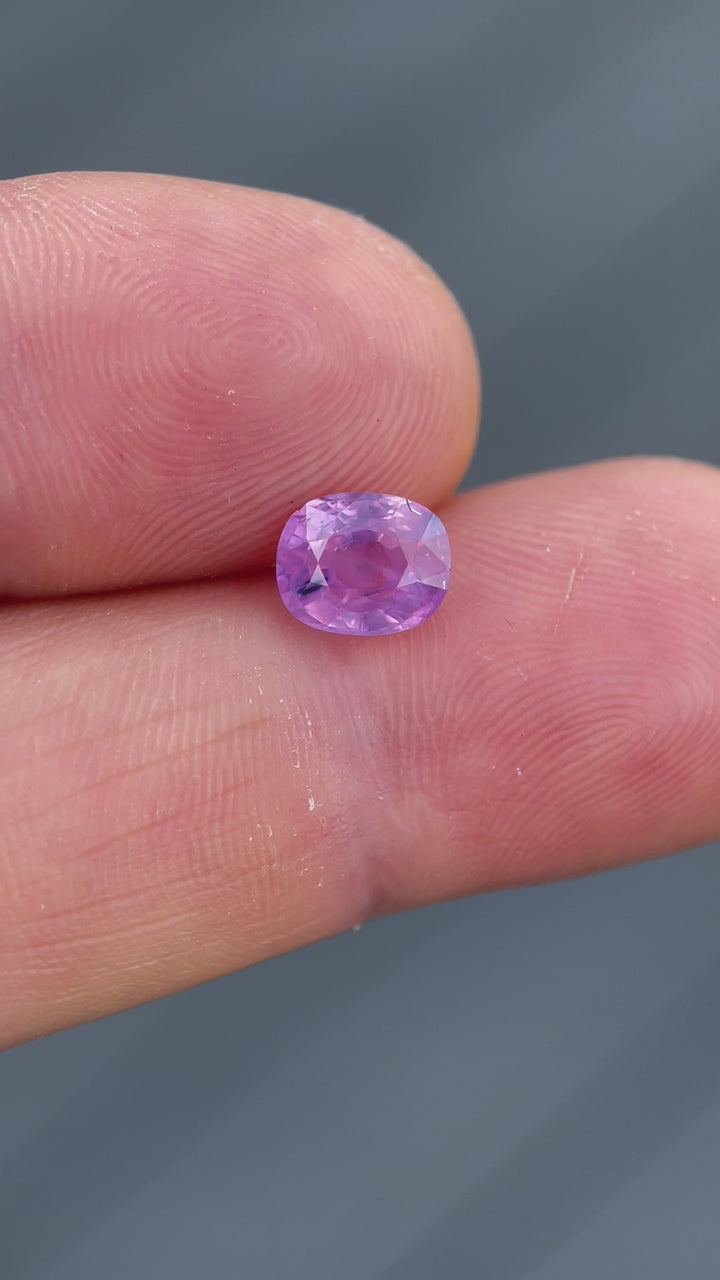 Video showcasing a 1.77ct opalescent pink and purple sapphire from Luc Yen, Vietnam, in a mix cushion cut, beautifully capturing its unique colors and clarity under different lighting.