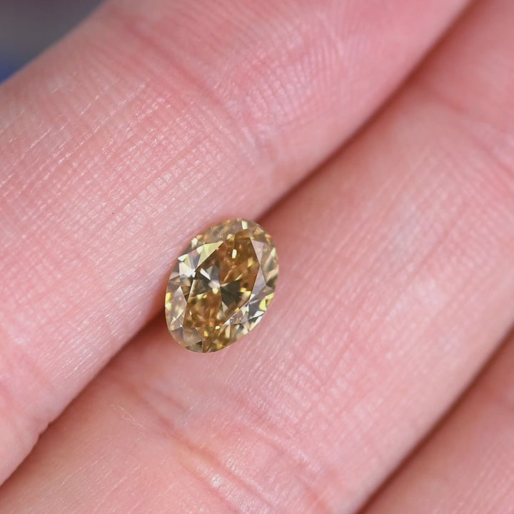 Oval diamond exhibiting green fluorescence under UV light highlighting rare optical effect.