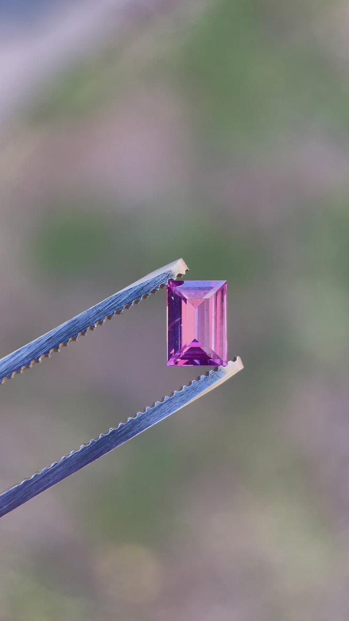 Engaging video showcasing a 1.10 carat sapphire with an emerald cut, capturing the gem's dynamic play of pink, purple, and mulberry colors, sourced from Sri Lanka.