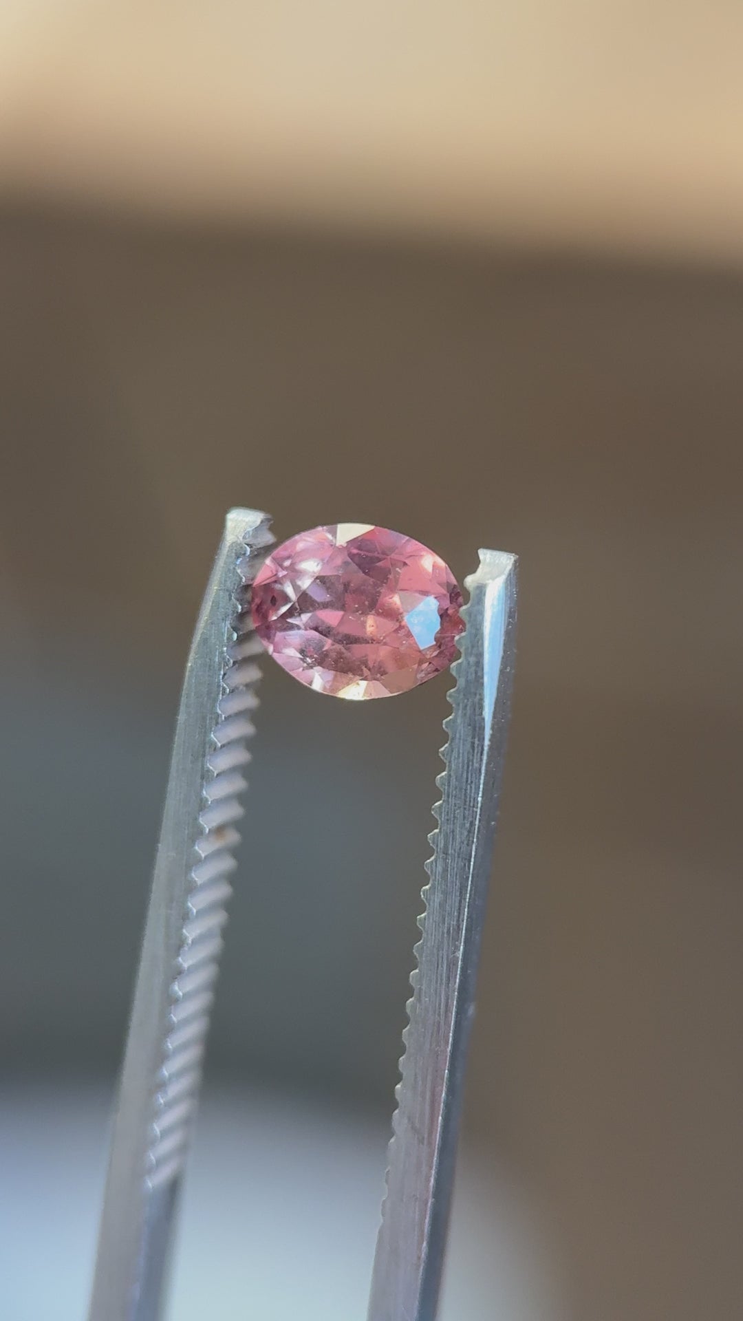 Video of a 0.95ct untreated color-shifting sapphire from Umba River, Tanzania showing strong fluorescence and vibrant orange-to-pink transition in natural light.