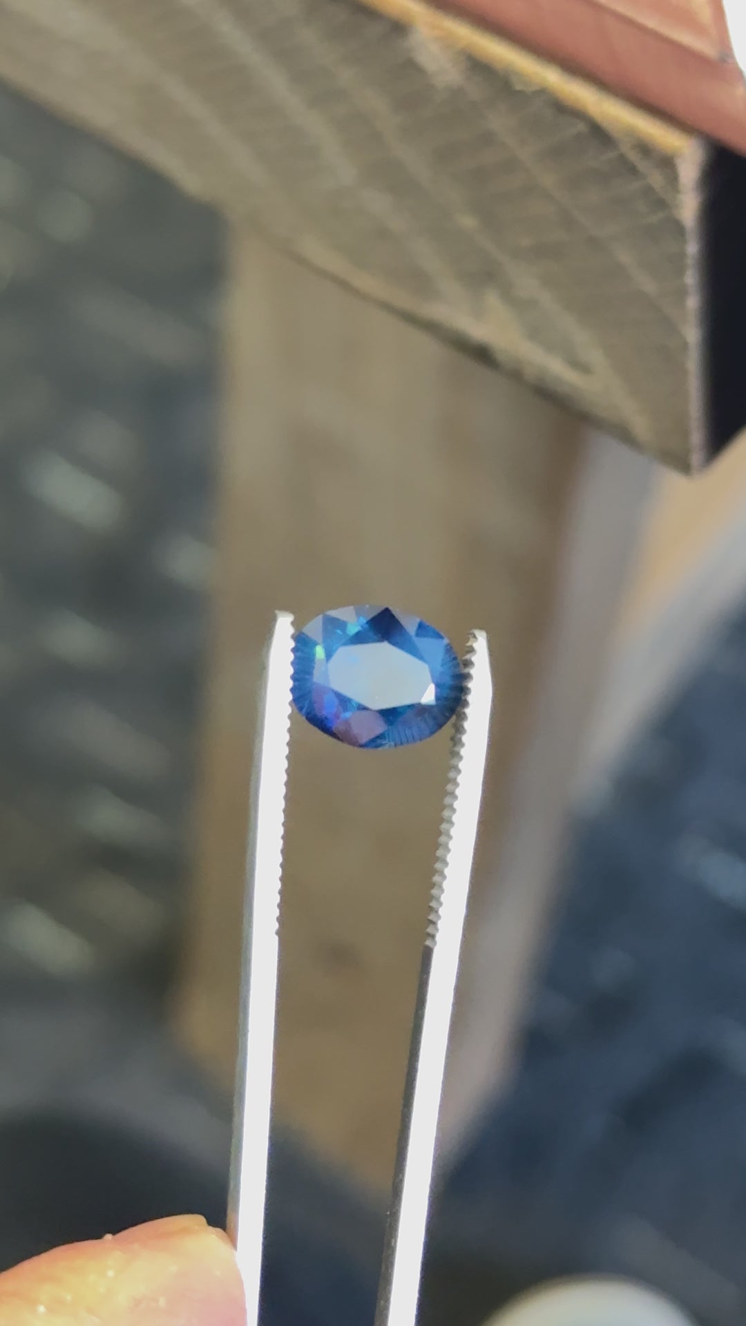Close-up of royal teal Nigerian sapphire in motion, emphasizing saturated body color and dynamic blue-green reflections.