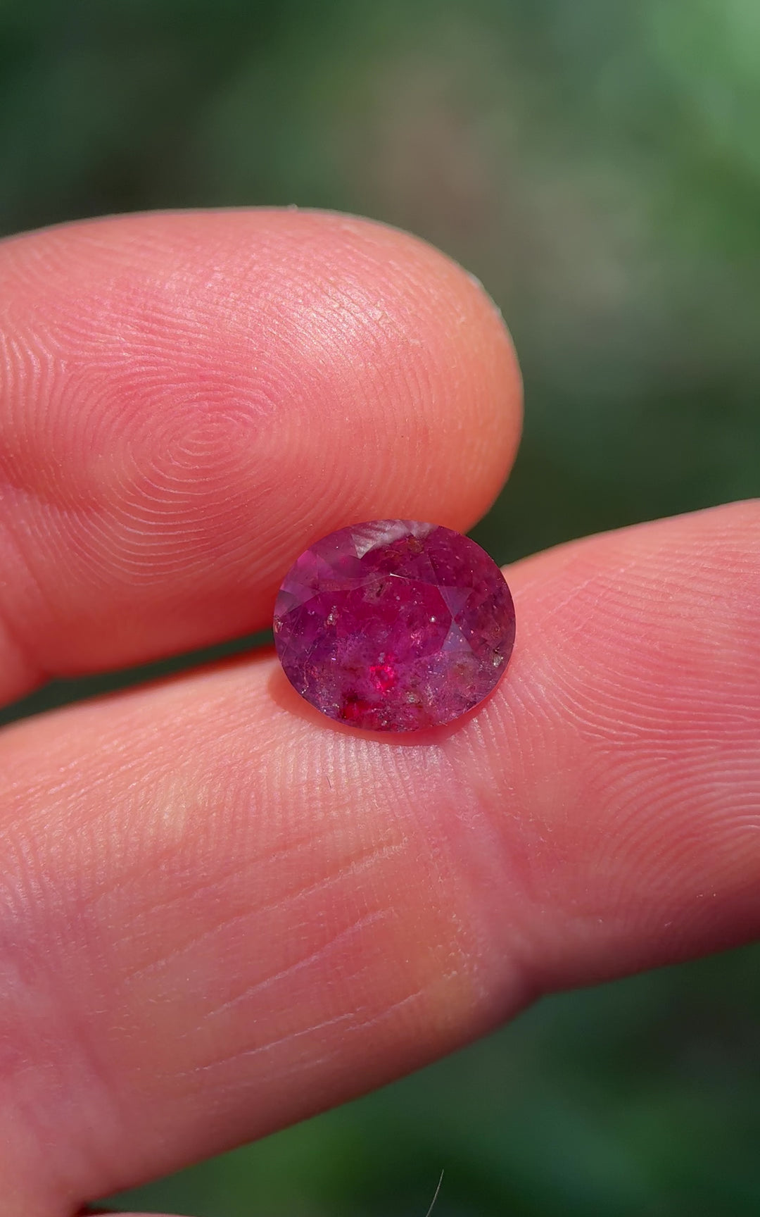 Macro video of 3.60 carat purplish red sapphire from Umba River, Tanzania rotating in hand to reveal brilliance and clarity