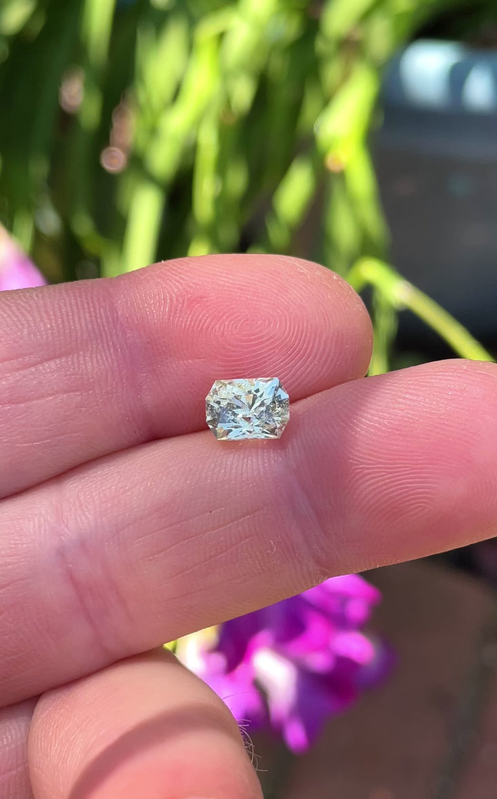 A custom-cut yellow-green sapphire shown in natural light, with intricate reflections in its 2.04-carat octagon-shaped cut.