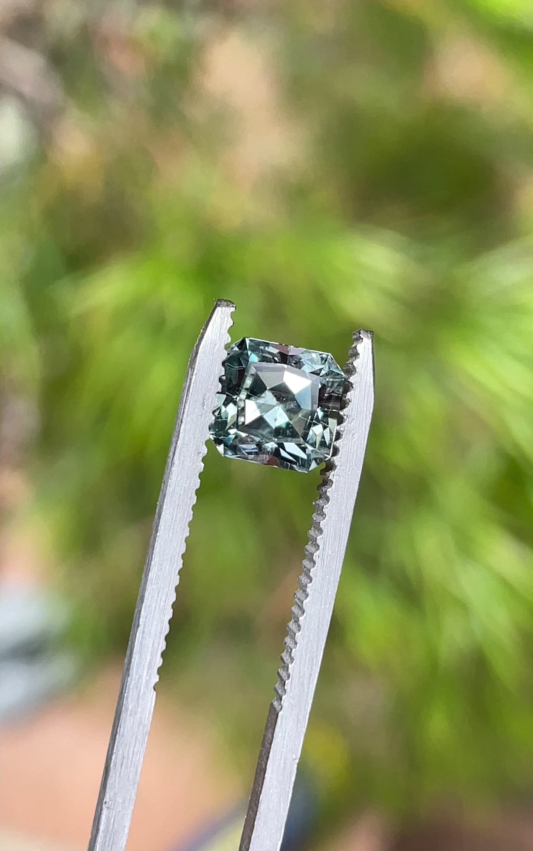 A rotating view of a 1.58-carat custom cut Montana sapphire, showcasing its steely sage grey green tones and brilliant clarity in natural light.