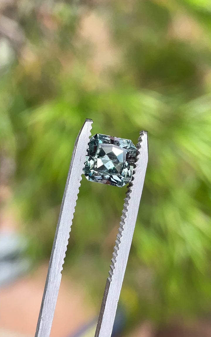 A rotating view of a 1.58-carat custom cut Montana sapphire, showcasing its steely sage grey green tones and brilliant clarity in natural light.