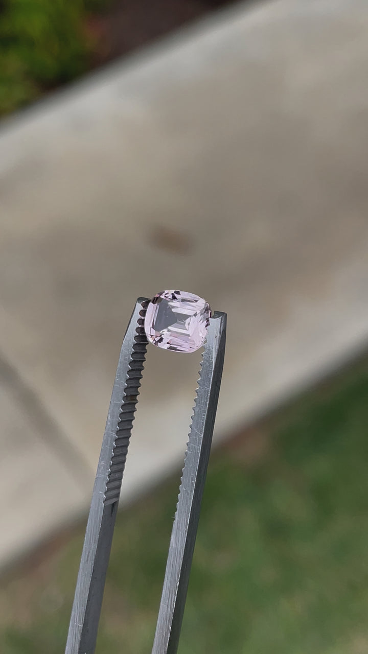 Close-up video of a 1.19-carat pastel yellow and peach sapphire from Sri Lanka, displaying its cushion modified cut. The stone is untreated, allowing its natural hues and brilliance to shine through.