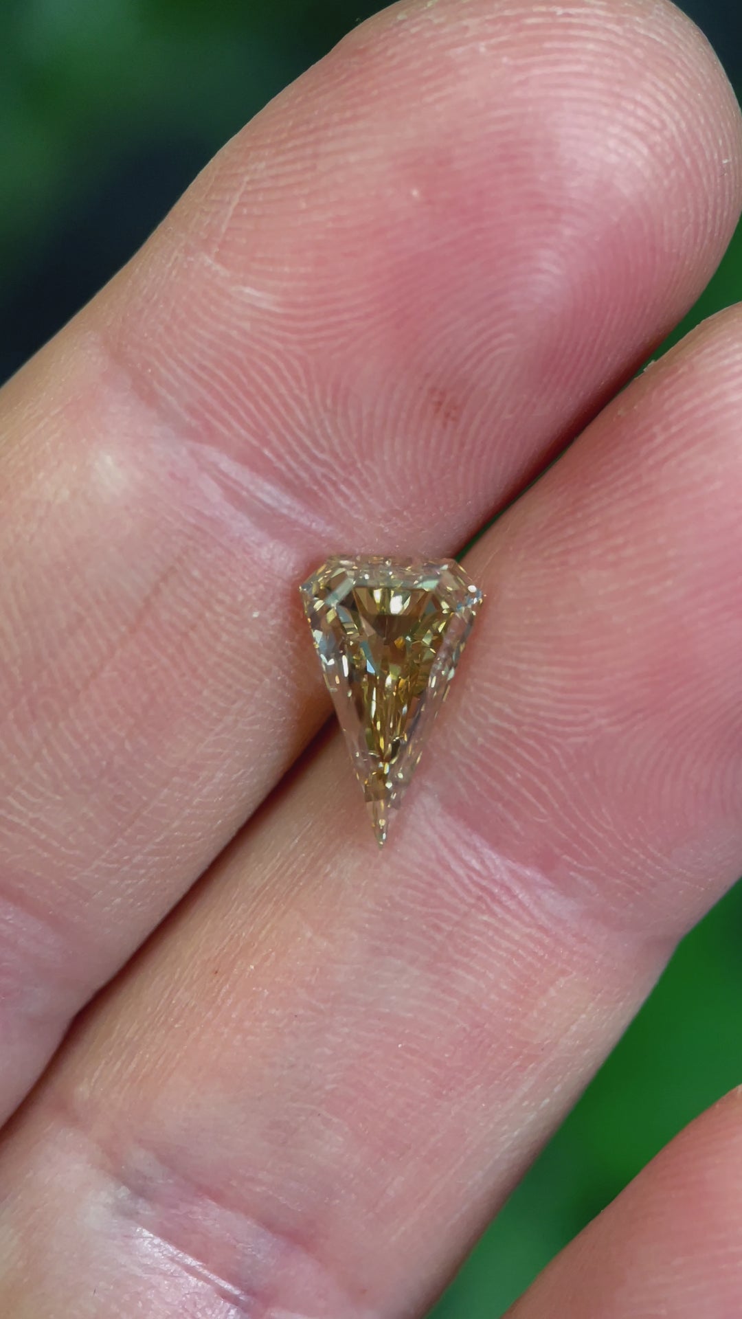 A high-resolution video of an ethically sourced 2.10ct kite-cut diamond, showcasing its natural champagne color and brilliance under natural lighting.