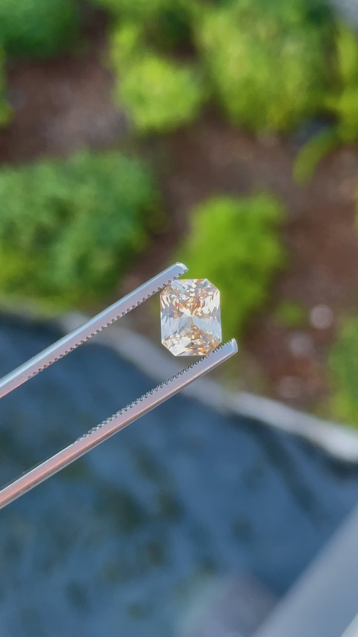 A 360-degree video showcasing the brilliance and facets of a 2.55-carat peach champagne sapphire. The octagonal mixed cut enhances its natural sparkle and warm tones.
