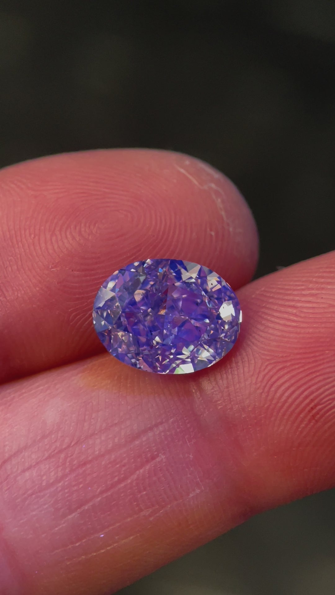 Close-up video of a 5.25ct Oval Brilliant Diamond from South Africa, revealing its light champagne color, strong blue fluorescence, and dazzling fire.