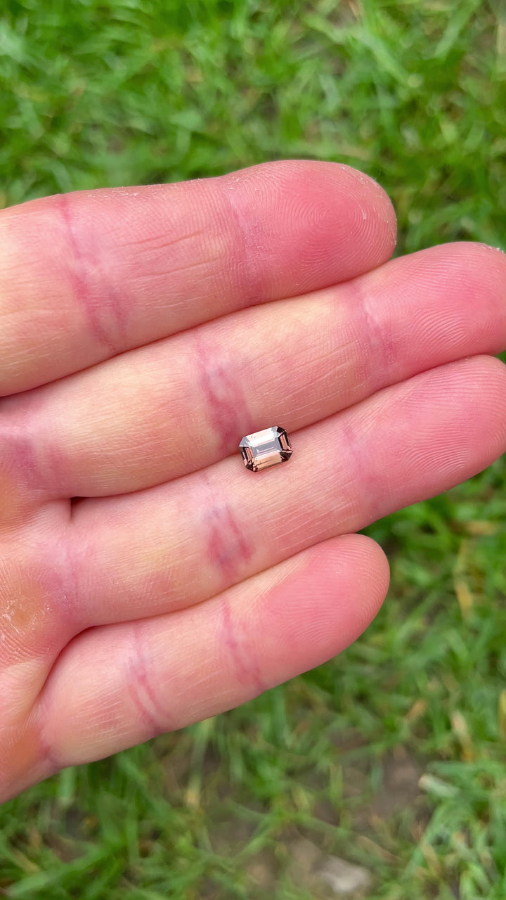 1.10-carat peach-pink-orange sapphir under different lighting angles to highlight clarity and step cut facets.