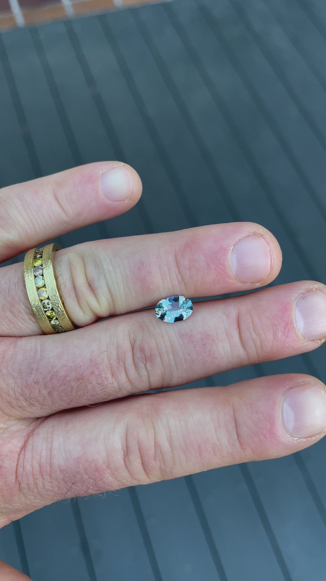 A 1.61-carat seafoam blue sapphire in oval mix brilliant cut, showcased in natural light to highlight its brilliance and vivid color.