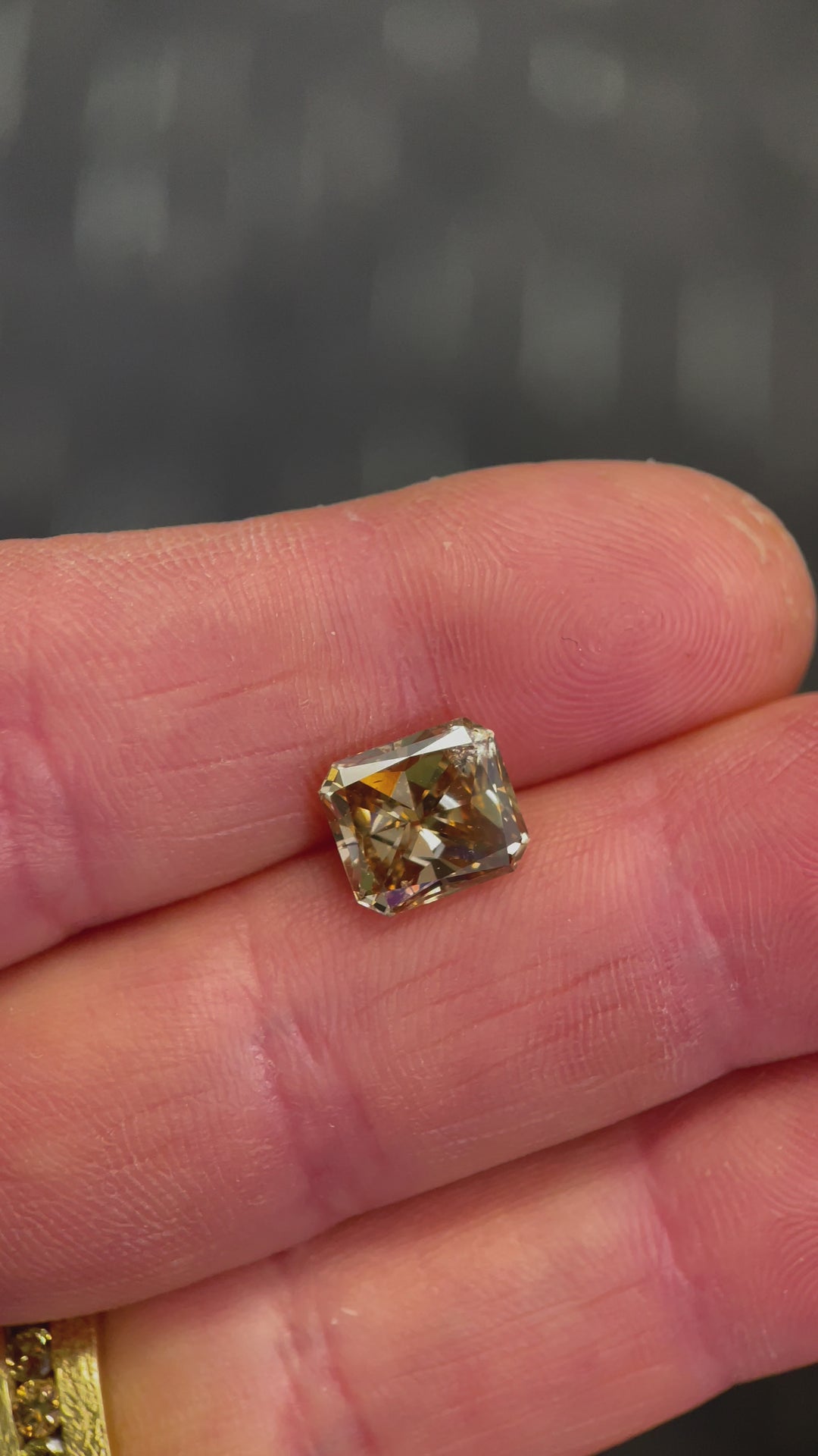 A high-resolution video of a 3.68-carat Argyle Mines diamond, highlighting its warm champagne tone and scintillating step-cut reflections.