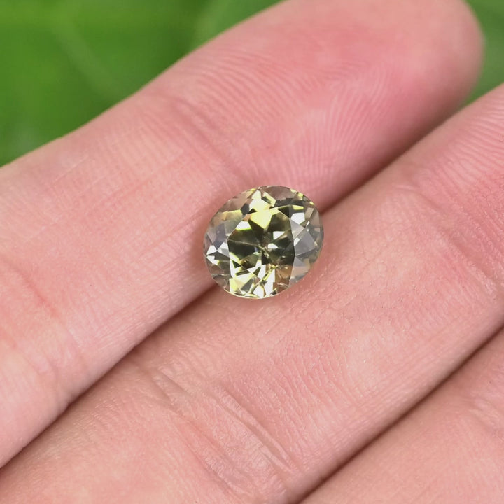 3.05 carat yellow champagne green Tanzanite oval gemstone rotating under natural light, custom mix brilliant cut from Merelani Hills Tanzania showing brilliance and color shift