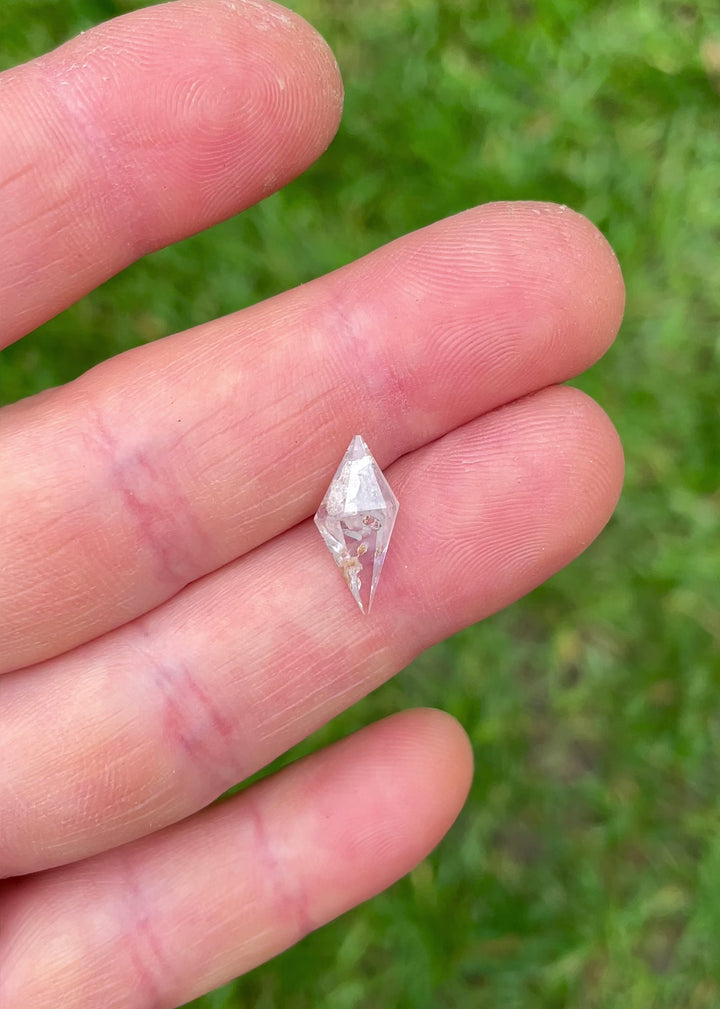 Macro video footage of a natural silvery gray Sri Lankan sapphire with internal inclusions and geometric facets, weighing 2.85 carats.