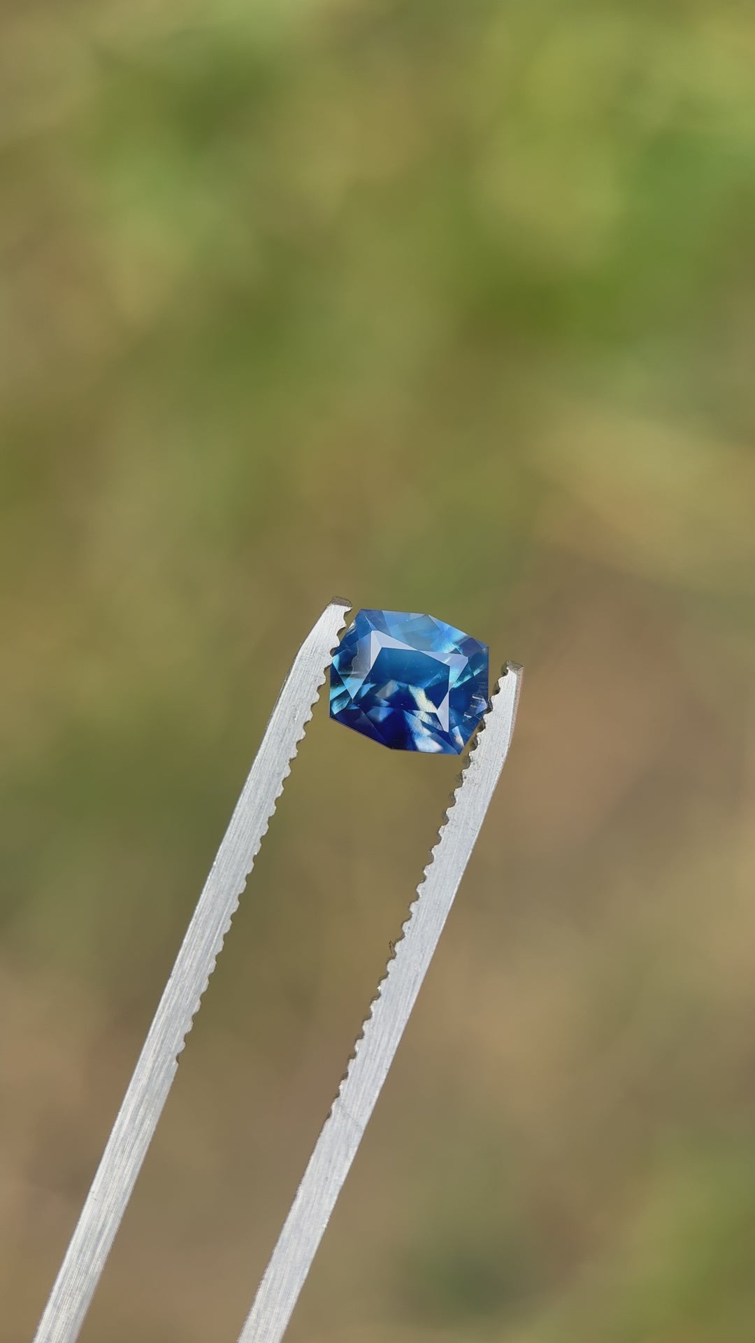 Rotating view of a 1.60-carat sky-denim and royal-blue opalescent parti sapphire from Diego, Madagascar, showing light play and brilliance in a precision custom geometric cushion cut.