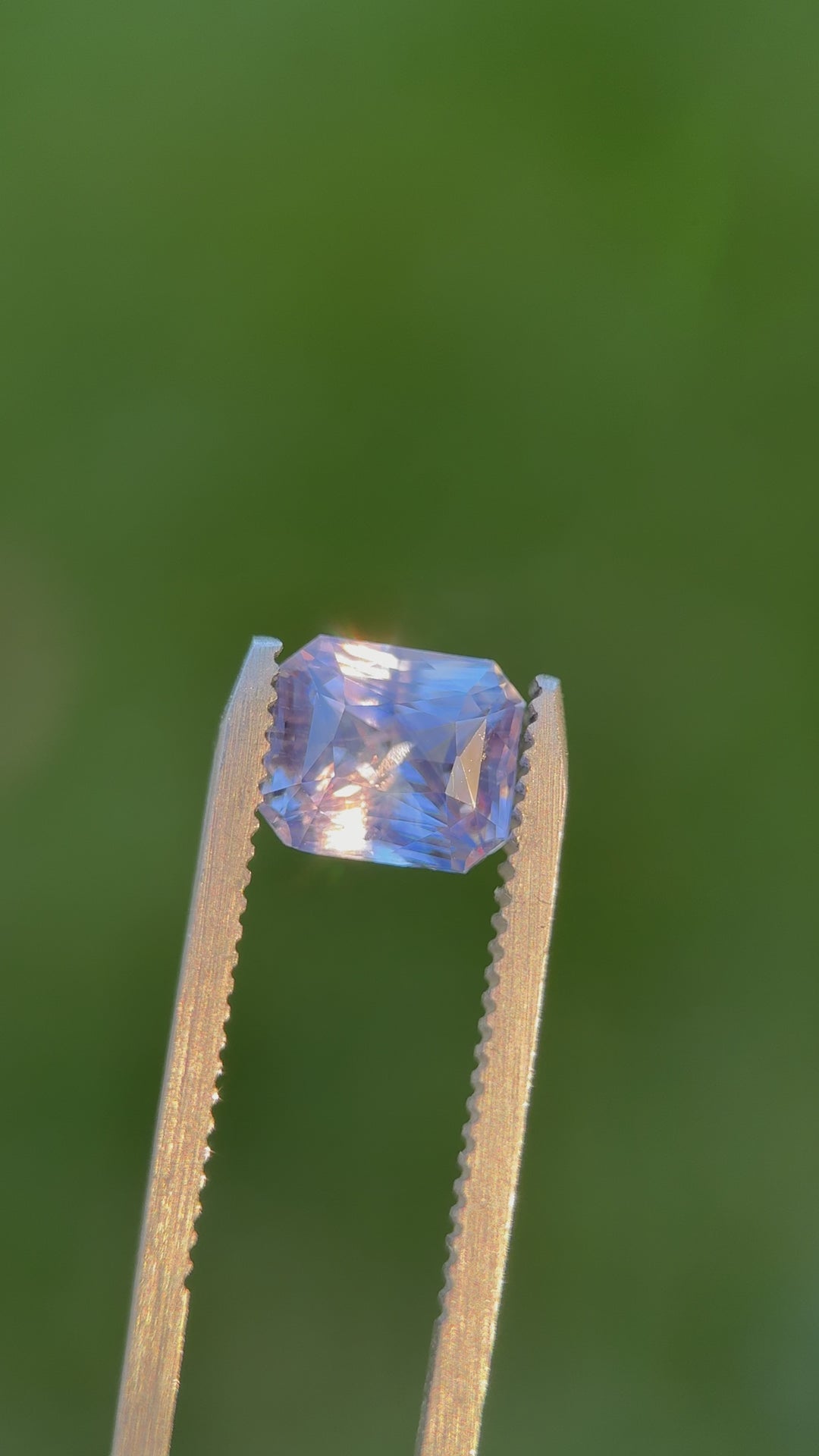 Video of a 2.70-carat radiant cut sapphire in lavender, violet, and blue tones from Sri Lanka, rotating under natural light to show its brilliance.