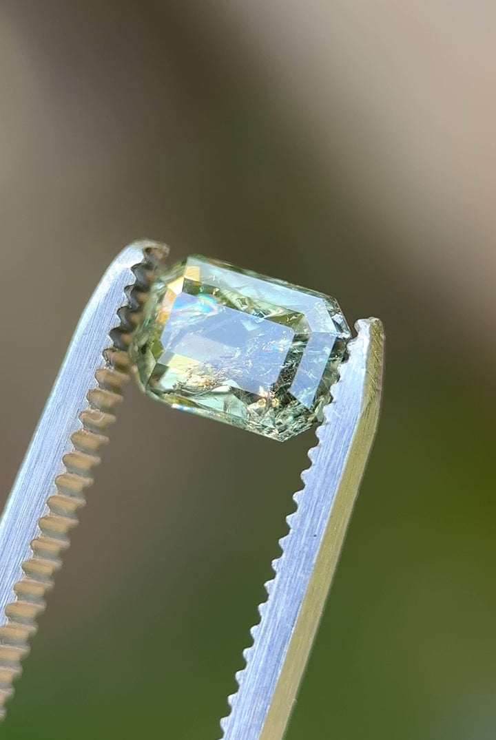 Rotating view of 2.06ct teal and earthy yellow sapphire in natural light, modified emerald cut, from Umba River Tanzania