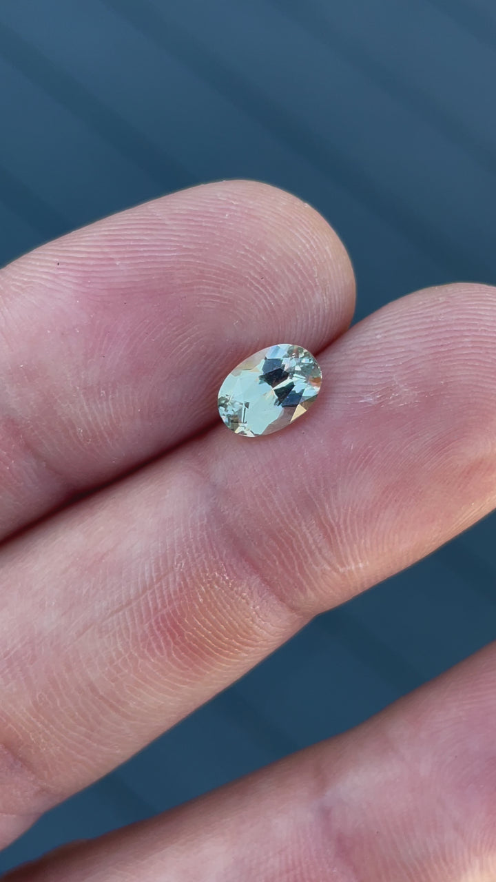 A rotating view of a 2.05-carat untreated Sri Lankan sapphire, highlighting its brilliant oval cut and color transition between gray and yellow tones.