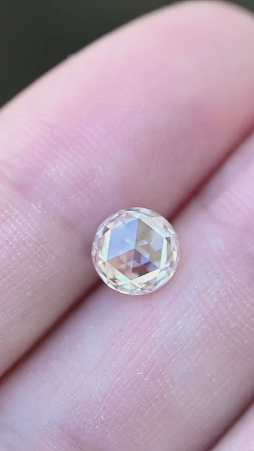 Video of a natural 1.14 carat blush champagne rose cut diamond displayed on fingertips, revealing warm champagne reflections and broad mirror-like facets in natural light.