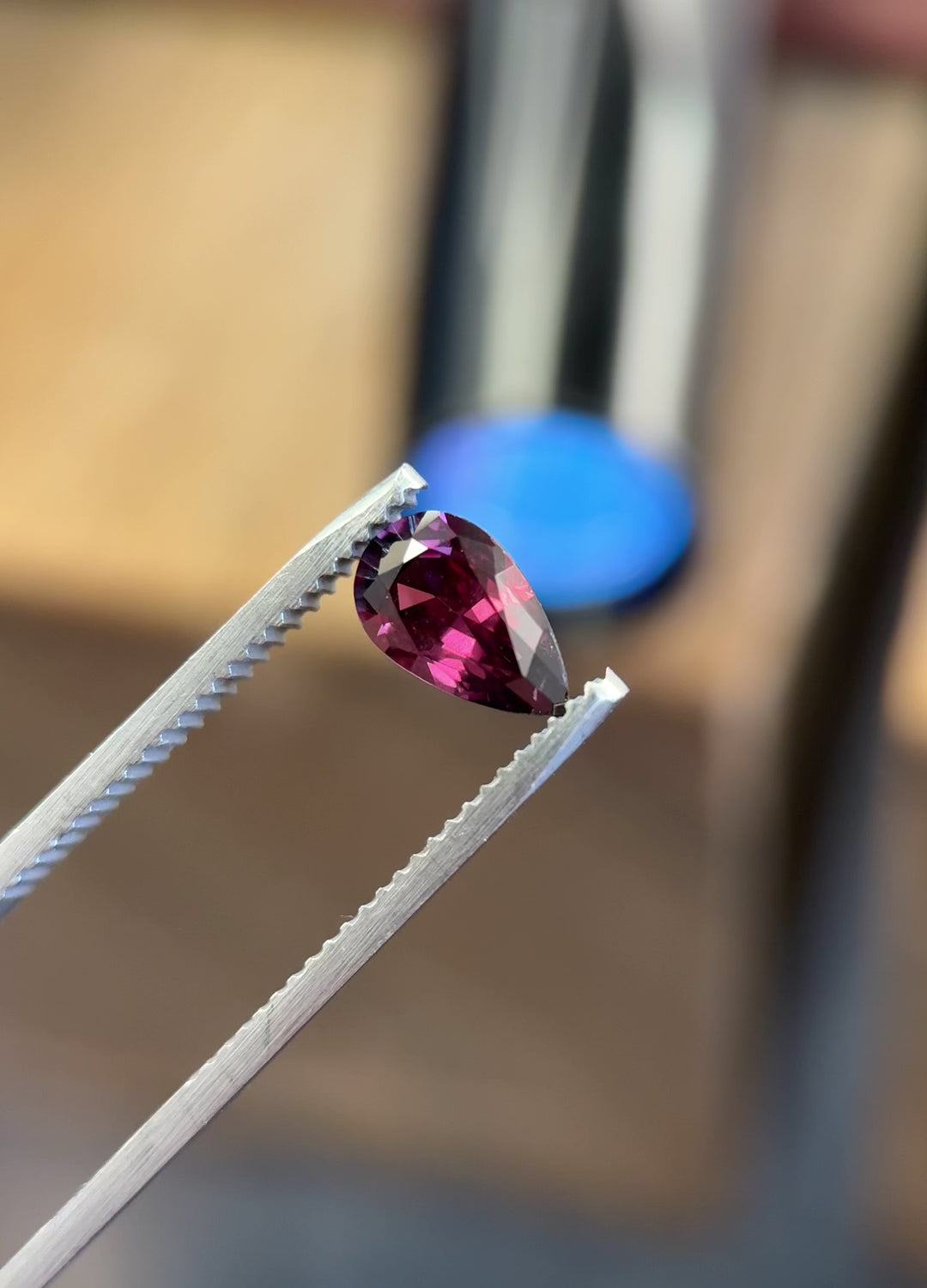 Rotating pear-shaped 1.39ct sapphire from Umba River showing red and purple hues under natural light