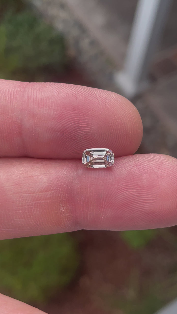 A 1.03-carat cushion-cut diamond with light fancy yellowish brown hues, captured in various lighting angles to showcase its depth, clarity, and brilliance.