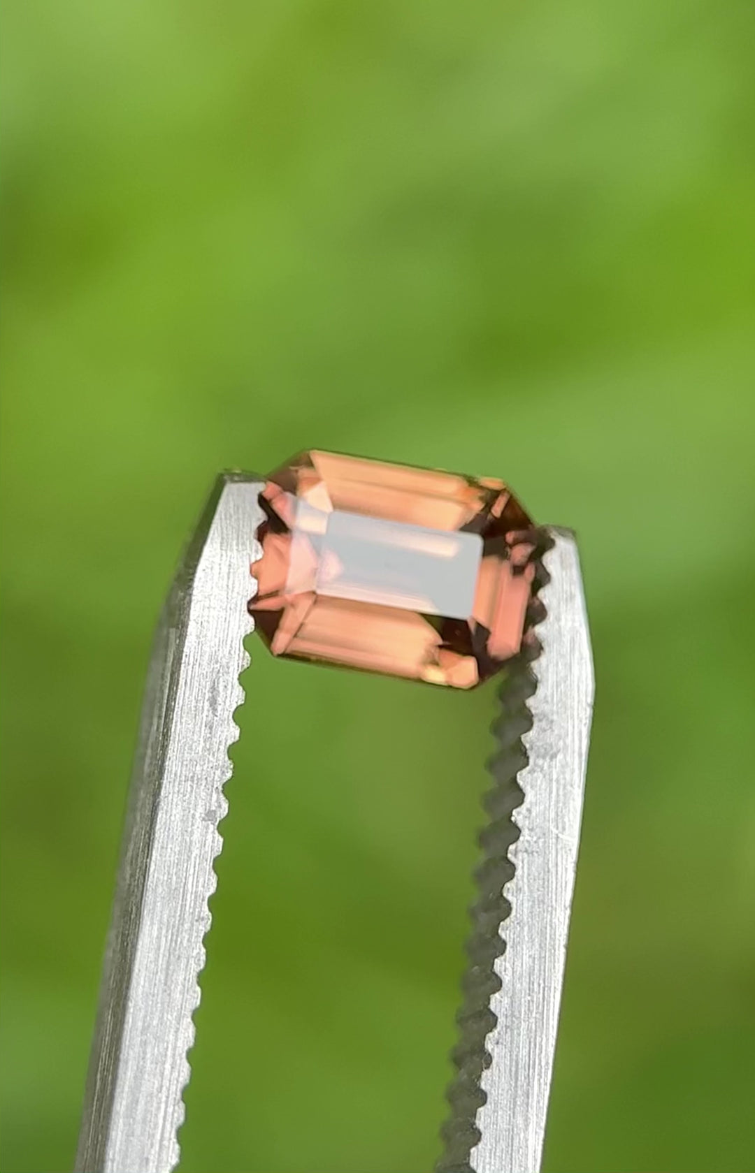 Rotating 1.10ct peach sapphire from Madagascar in emerald cut, showing natural color and sparkle.