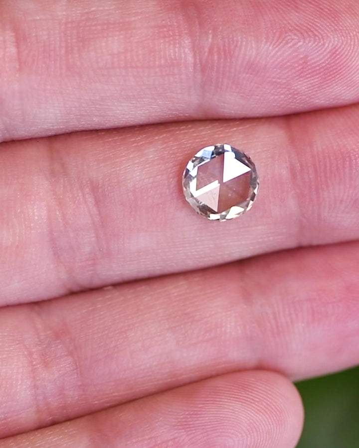 Video of a 1.62 carat light green rose cut diamond from South Africa shown on a fingertip under natural daylight. The GIA certified SI2 clarity diamond highlights its flat-top rose cut brilliance and gentle green hue.